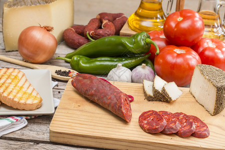 餐桌上的不同西班牙健康食品香肠奶酪西红柿胡椒大蒜图片