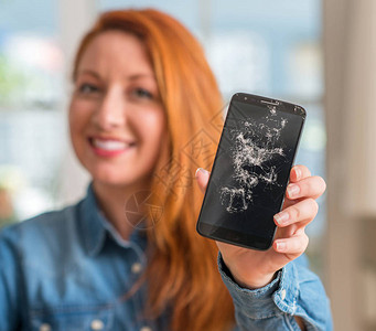 红发女人拿着破智能手机图片