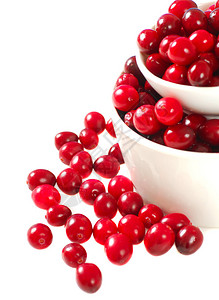 两个碗蔓越莓溢出到白色的表面图片