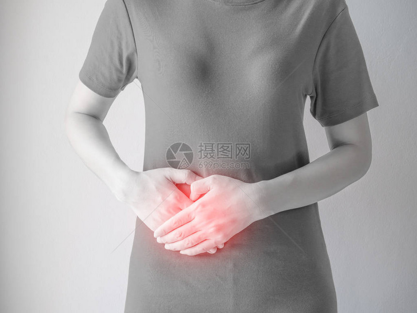 白墙背景上的中年妇女胃痛图片