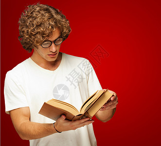 一个人阅读一本书的肖像在红背景图片