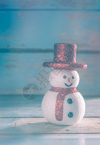 圣诞雪人和装饰在垃圾蓝色木制背景图片