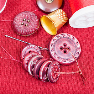 缝线纽扣针头红织物上针头的波宾图片