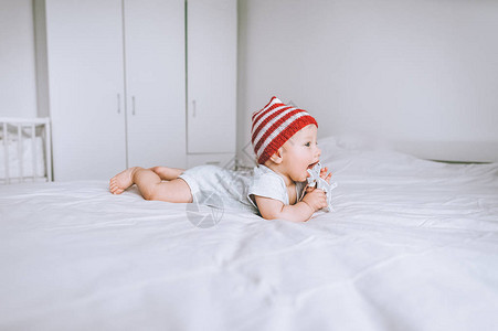 穿着红帽和白条纹帽子的婴儿在图片