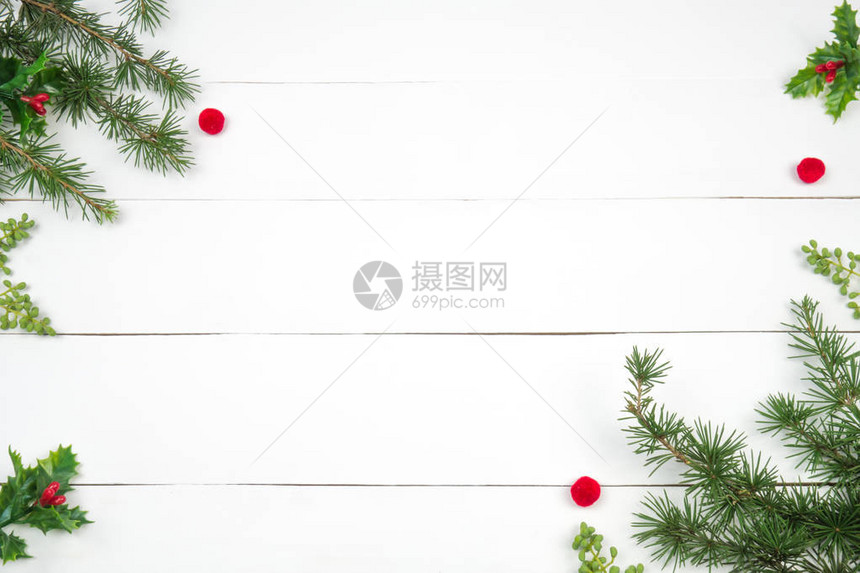 创意圣诞布局冷杉树枝和红色绒球白木背景白色复制空间边界安排图片