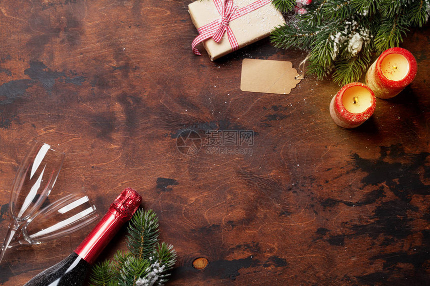 圣诞礼物盒蜡烛香槟和木本上雪所覆盖的fir树枝顶端视图xma背景图片