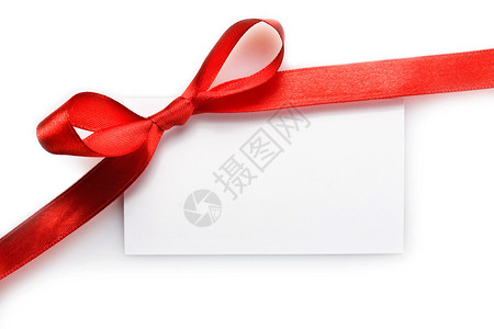 用红色缎带蝴蝶结系的空白礼品标签被白色隔图片