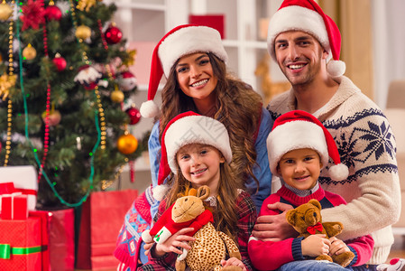 在家庆祝圣诞节时年轻幸福的家庭在图片
