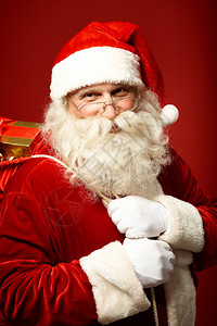 快乐圣诞老人的肖像带着礼物拿着麻袋图片