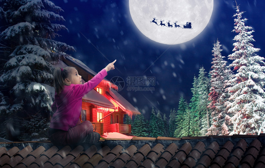 女孩坐在屋顶上在圣诞节前夕指向天空中图片