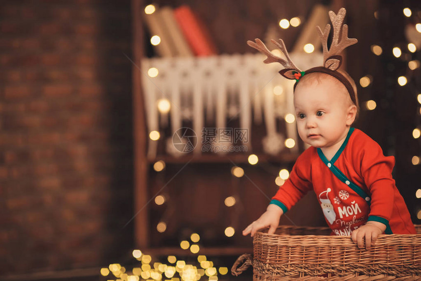 坐在柳条筐里的驯鹿角的小男婴新年图片