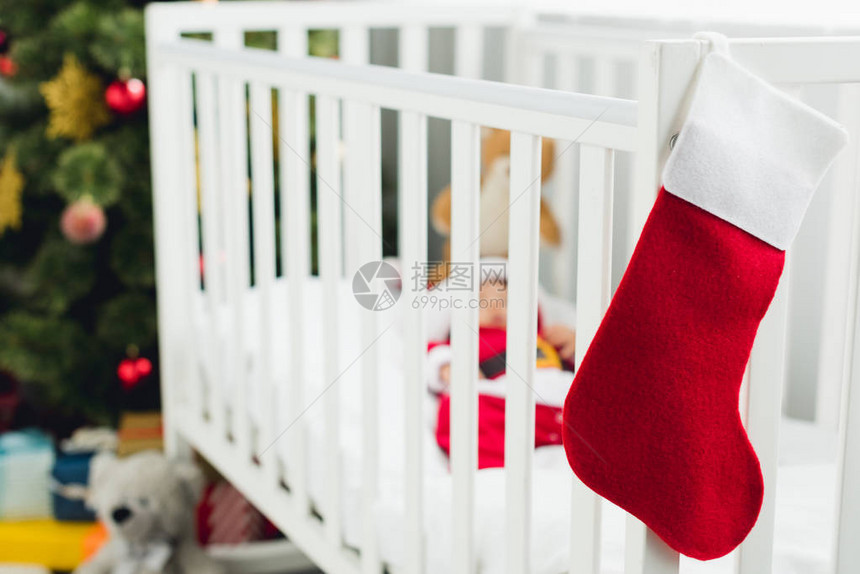 小宝在圣塔西装躺在婴儿床与圣诞节礼图片