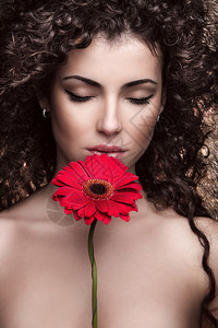 美丽的黑发女人与红花背景图片