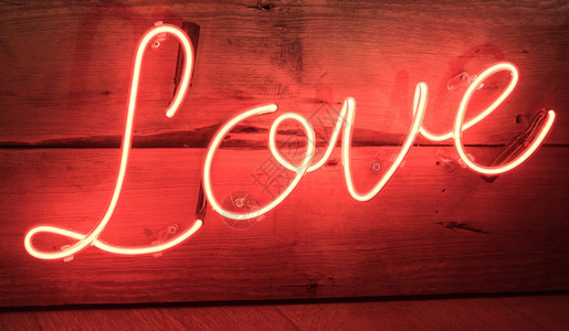 红色霓虹灯爱情标志与木制背景背景图片