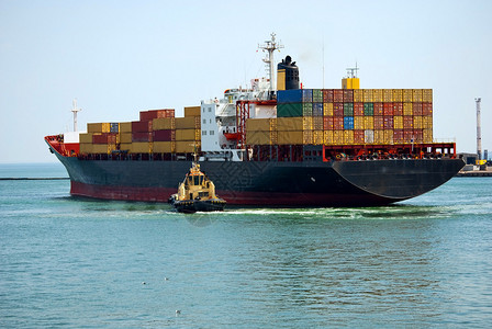 小型拖船使装有货集装箱的大型集装箱船舶的图片