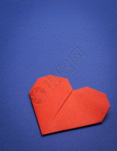 蓝纸背景上的红色折纸心背景图片