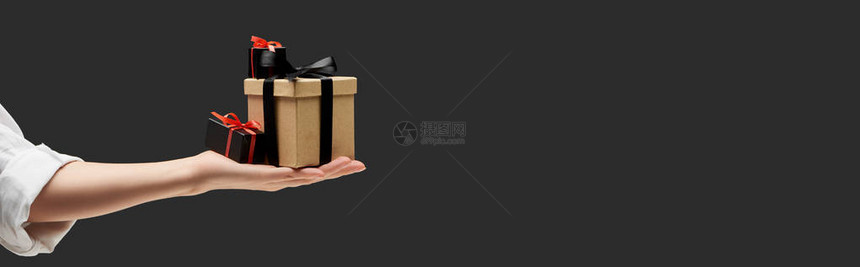 妇女手拿着礼品盒在黑色全景图片