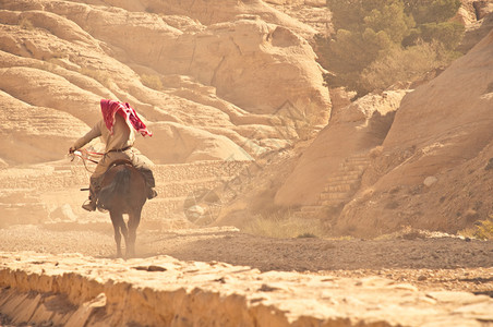 阿拉伯男子骑马在岩图片