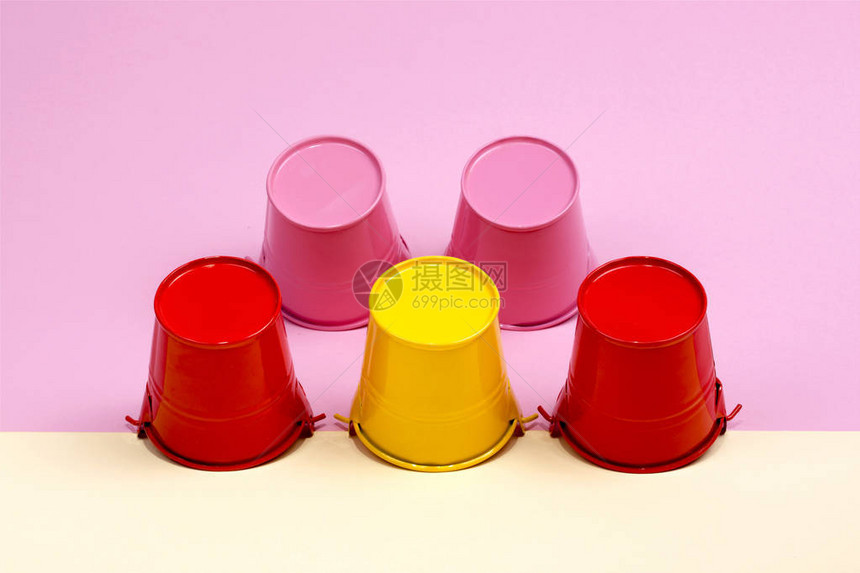 彩色背景上的粉红色红色和黄色水桶图片