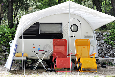 现代大篷车前面有两把彩色野营椅背景图片