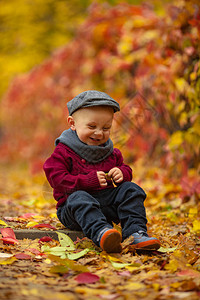 小男孩带着帽子围巾和毛衣笑着图片