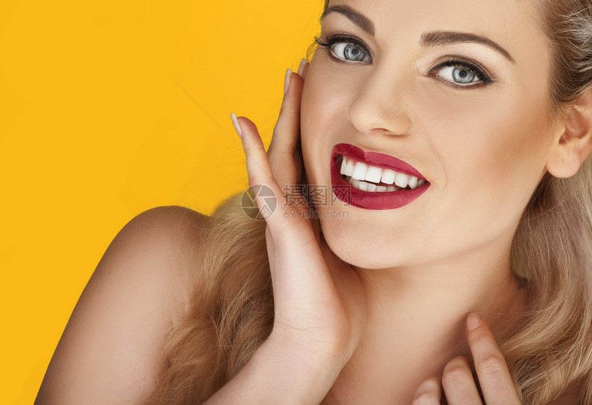 在黄色工作室背景上刻出一个感红嘴唇的美丽魅力模特脸图片