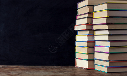 学校黑板背景的桌子上书架中的书本图片