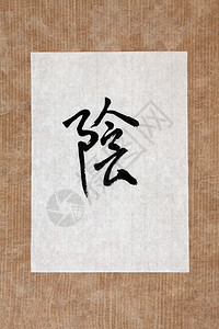 在棕色纸背景的宣纸上的普通话书法脚本中的国阴符号图片