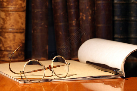 古老的眼镜纸笔和书本笔死背景图片