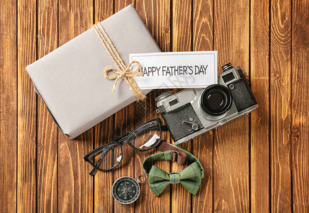 礼物盒照相机和木背景的男饰物父亲节庆图片