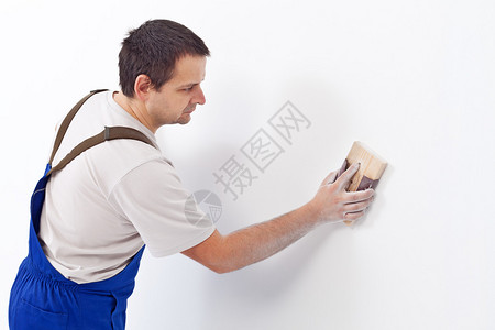 工人用砂纸擦刷墙壁准图片