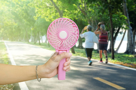 夏季炎热天气时在公共园手持粉红图片