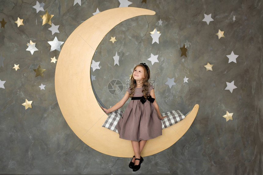 穿灰色裙子的小女孩正坐在月亮上图片