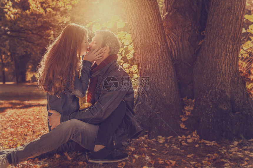 夕阳下的情侣在树上接吻图片