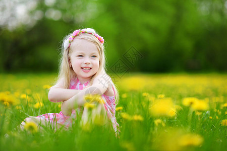 可爱的小女孩在美丽的春日盛开的蒲公英草地上孩子在户外采图片