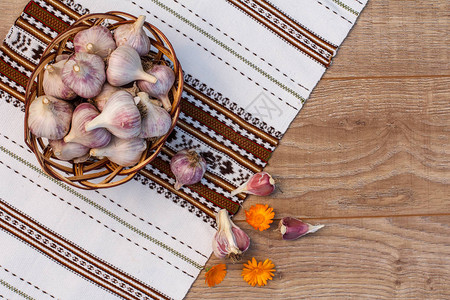 躺在毛巾上木板上有乌克兰民族装饰品的柳条篮子里拉皮大蒜图片