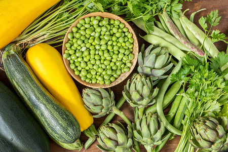 新鲜的有机绿色蔬菜木地板与复制空间绿色和黄色蔬菜背景健康饮食背景素图片