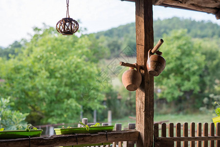 一座古老的乡村别墅的木门廊俯瞰着院子里一个阳光明媚的绿色花园背景图片