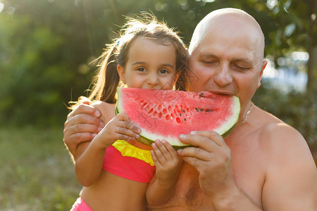 白发老人带着孙女吃西瓜炎热的夏日七月图片
