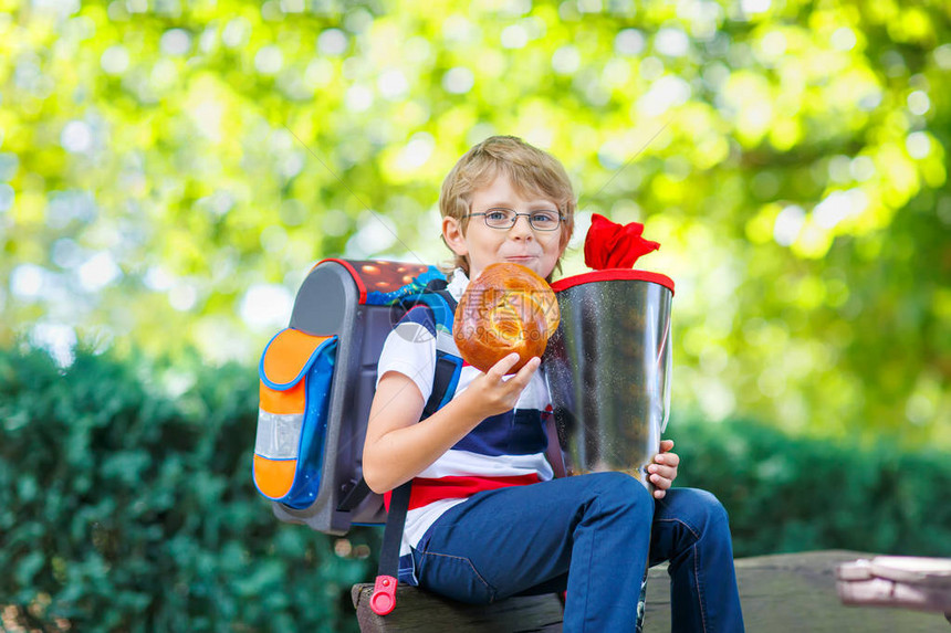 快乐的小男孩在上学的第一天戴着眼镜和背包或书包图片