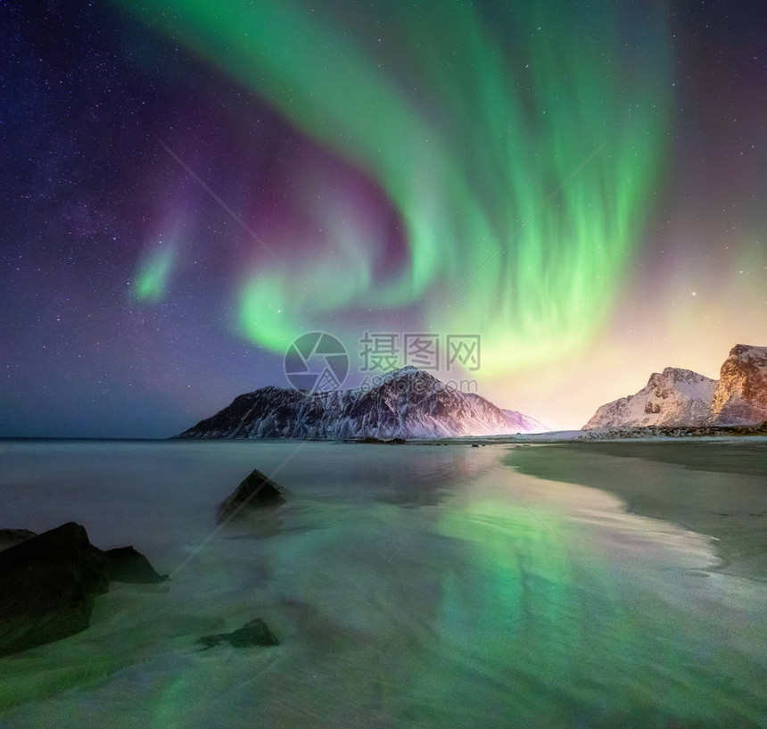 挪威罗弗敦群岛上的北极光山脉和海滩上方的绿色北极光与极光的夜空与极光的夜冬天风景挪图片