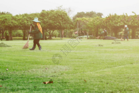 女人在草坪上把地板扫得干净图片