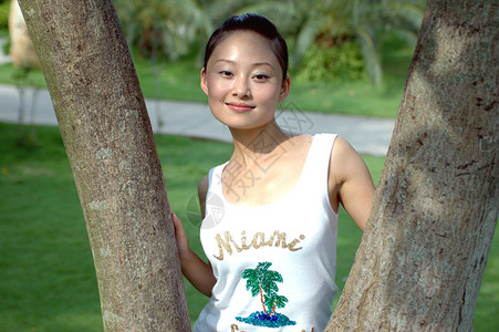 女孩在公园里站在树旁微笑地放松穿着传统的华图片