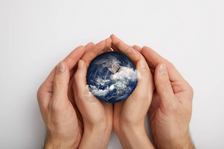 4月22地球日以灰色背景持有地球模型的顶部视图设计图片