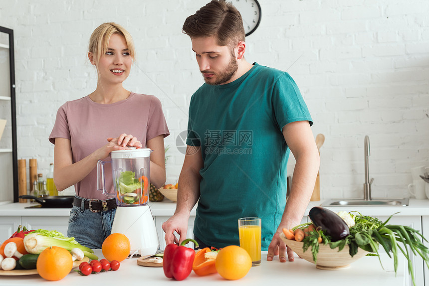 两对素食者在厨房准备蔬菜汁配图片