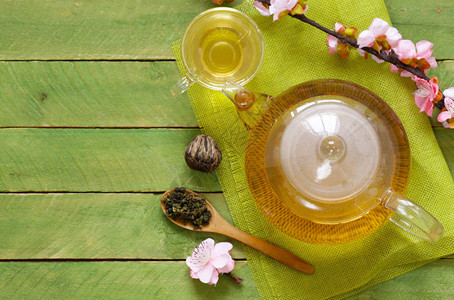 茶壶里的绿茶上面有一枝樱花图片