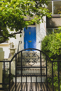 房子的白色门面有蓝色门的图片