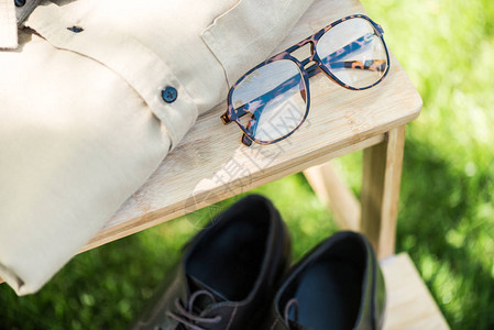 草地木制楼梯上的包装眼镜皮鞋和男衬衣有图片