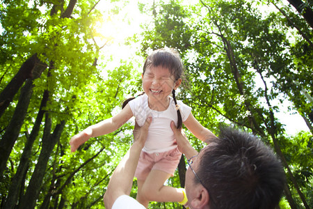 快乐的小女孩与父亲在绿林图片