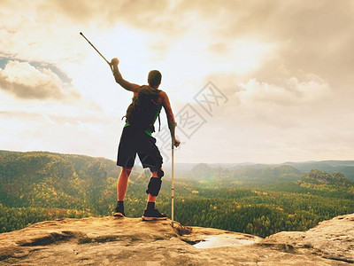 大自然中拄着拐杖的人拄着拐杖断腿的游客绷带伤腿的旅行者留在岩石观点图片